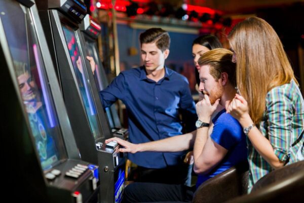 A group of people playing slot machines.