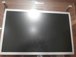 A LTM220MT05-L02, refurbished monitor is sitting on a table in front of a glass door.