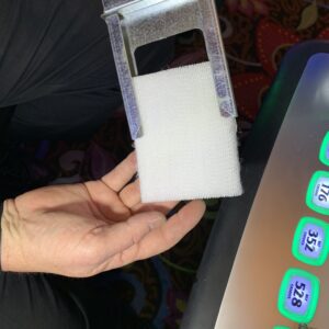 A person holding a 3M HAF Air filter for use with AGS and Cadillac Jack games in front of a slot machine.