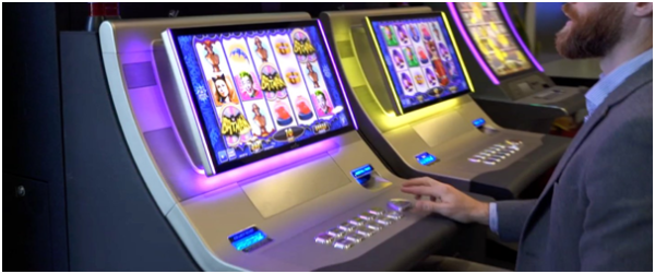 A man is playing an Aristocrat Helix Spin Bash Assembly button in a casino. GETT Part BTN161.