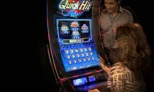 A woman is playing a slot machine at a casino.