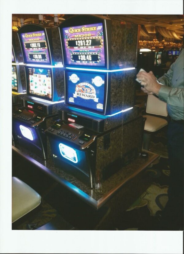 A man standing in front of a slot machine.