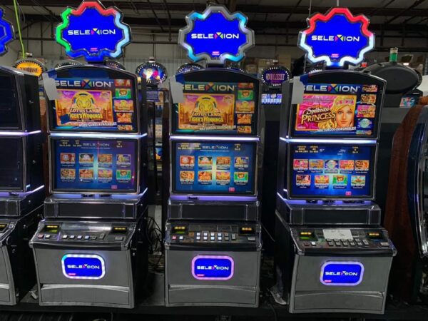 A row of Konami slot machines in a warehouse.