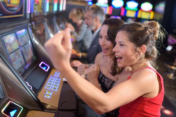 A group of women playing slot machines.