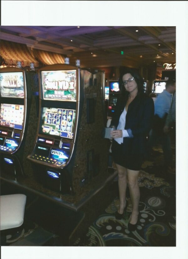 A woman standing in front of slot machines.