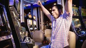 A man in front of a slot machine in a casino.