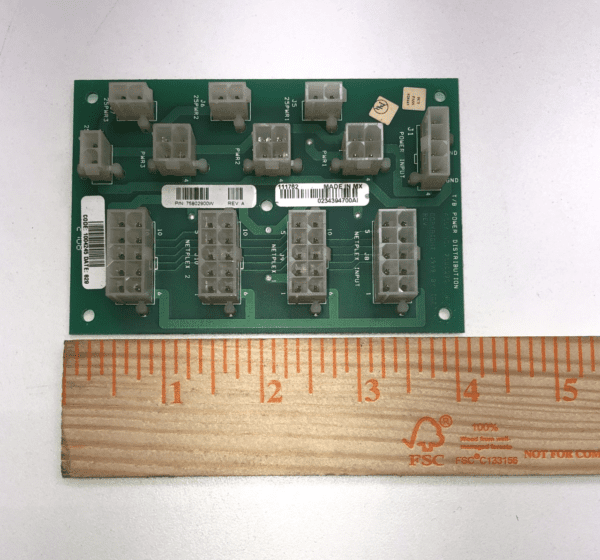 A green IGT AVP Netplex Power Distribution Board with a ruler next to it.