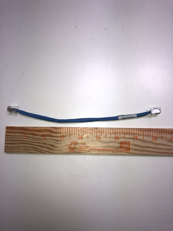 A blue JCM Cable for WBA and UBA Bill acceptor with a ruler next to it.