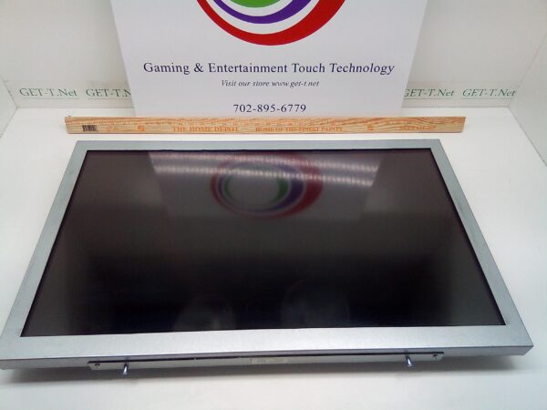 A 32" Tatung LCD SN # 300040. GETT Part LCDMR-100 monitor is sitting on a table in front of a sign.