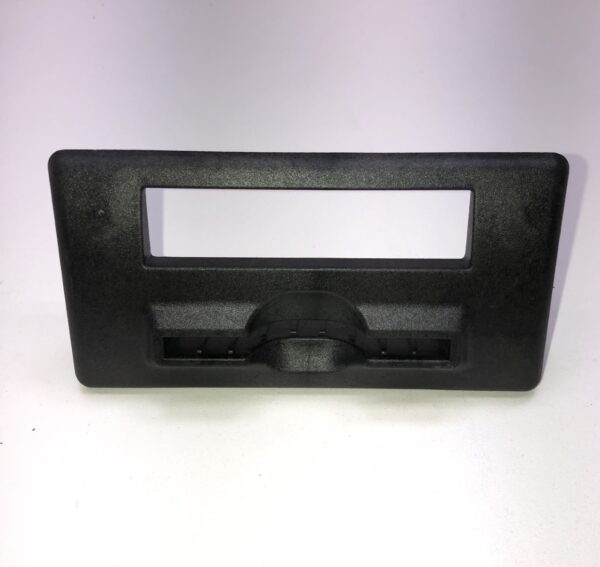 A Ticket Bezel, Black, Four Screw heads plastic cover for a car radio.