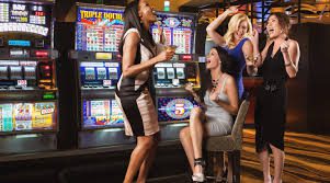 A group of women playing Coin Mech Coin Comparitor for IGT Games in a casino.