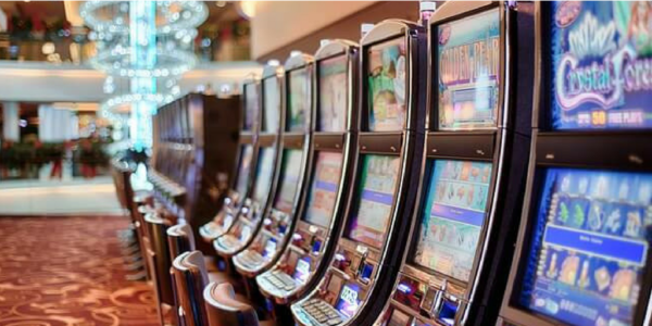 A row of WMS BB1 20-Line, 5-Digit, 7-sec Display Board (6779-018026-01-00) slot machines in a casino.