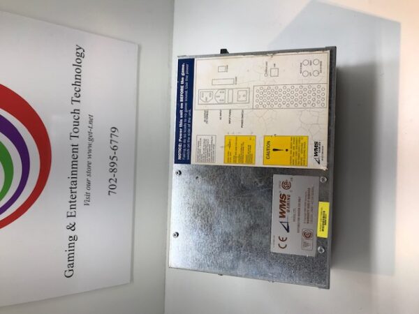 A box containing the WMS BBII Power Supply, WMS Part A-018396-01-01 and GETT Part PSUP188 logo on it sitting in front of a sign.