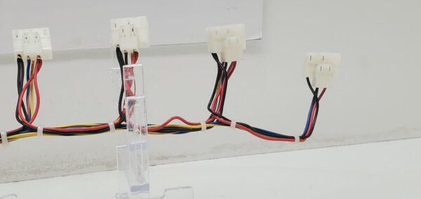 A group of IGT Trimline Game, Button Deck Wiring Harness. 10 Button Harness. GETT Part CABL121 wires and wires on a table.