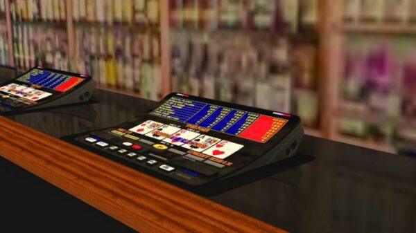 A casino table with several gaming machines in front of it, featuring the New Button Kit- Fits IGT Game King and I960 games. Small Square Push Button Set (10pcs). GETT Part BTN107.