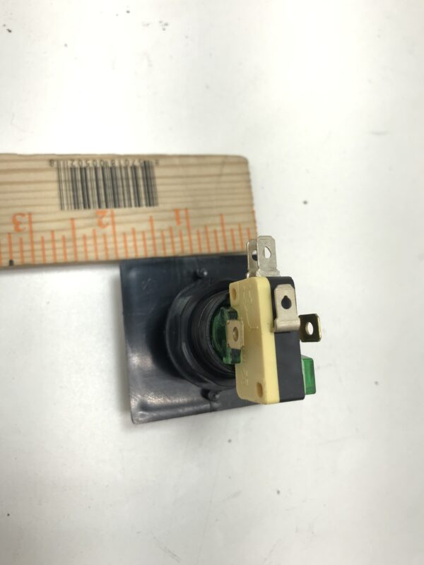 A Gamesman Buttons- 570 Series, 2 inch button length switch with a ruler next to it.