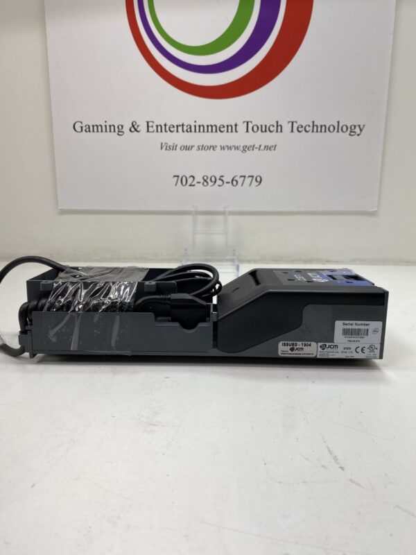 A JCM GEN5 Printer with Tray and Wire Harness. GETT Part Printer110 logo on a table.