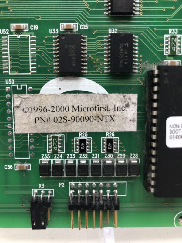 A green Bally 02S-90090-NTX pcb with a number of electronic components on it.