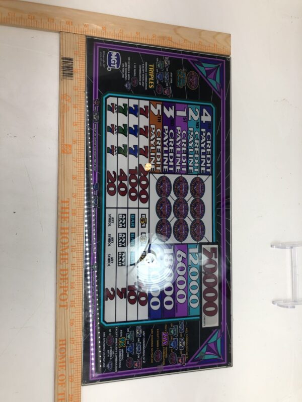 A board with an IGT S2000 Triple Diamond 5 Coin PayTable Top Glass with 50,000 Coin Insert in Top Award on it.