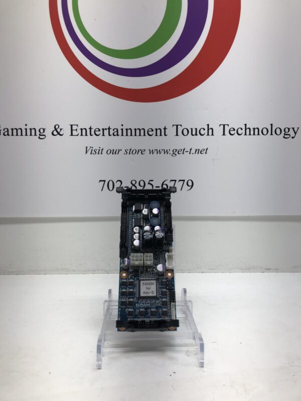 A Reel Driver Board for Konami Advantage 5, 5 reel and 3 reel. Also listed as Konami Part PWB (AG2)111128470000. Also listed as Konami Part CT3B000703. GETT Part RDB105 gaming and entertainment technology board in front of a sign.