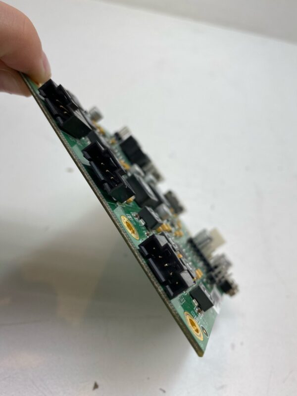 A person holding a small piece of the Amp for use with IGT Games. IGT Part E189010. GETT Part AMP103 computer board.
