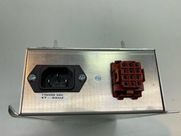 A small metal box with a red and black wire, the 110V-220V, 60W Power Supply with Custom 12-Pin Plug, Part # 780-027-50 by GETT (PSUP212).