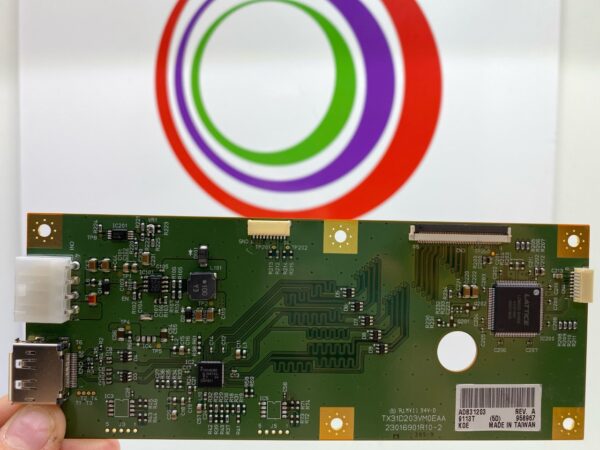 A person is holding up a TCon Board Part ADB31203 with a logo on it.