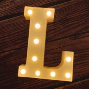 A yellow LED Marquee Letter L on a wooden table.