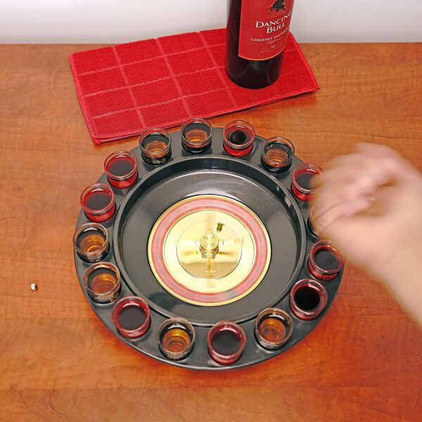 A person is holding a Novelties Shot Glass Roulette Complete Set drinking game, 16PCS, Red/Black on a plate.