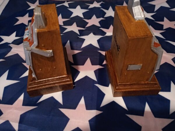 Two Harrah's 1997 Limited Edition Set Of Two Miniature Slot Machine bookends on top of an american flag.