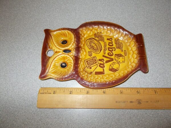A Vintage Las Vegas Nevada travel tourist souvenir ceramic Owl shaped ashtray on a ruler.