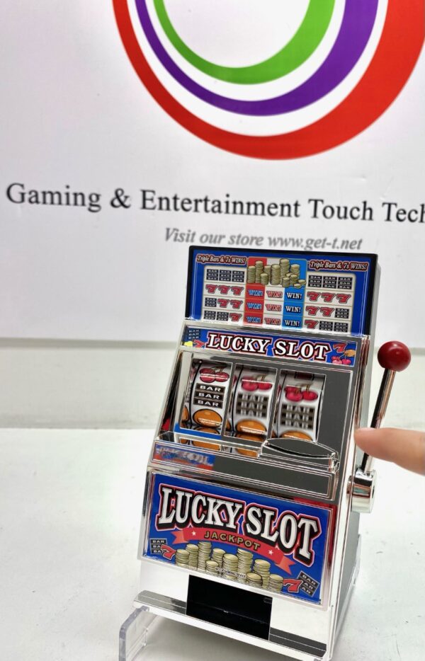 A person is holding a Lucky Slot Machine Bank in front of a gaming and entertainment touch tech logo.
