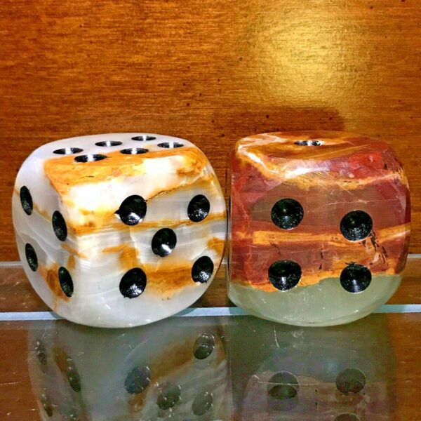 A pair of Large Carved Onyx Mid-Century Modern Dice Sculpture - Set of 2 with black and white numbers on them.
