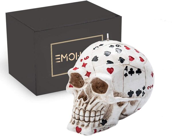 A Poker Skull Candle with playing cards in front of a box.