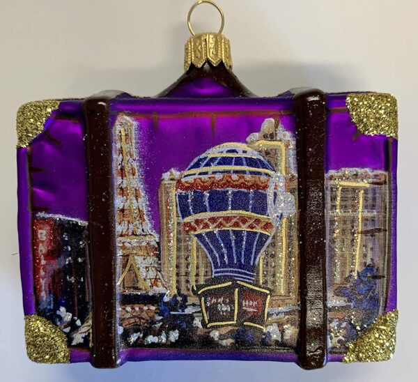 A purple suitcase with a Las Vegas Nevada Travel Suitcase Polish Glass Christmas Ornament ONE Decoration on it.